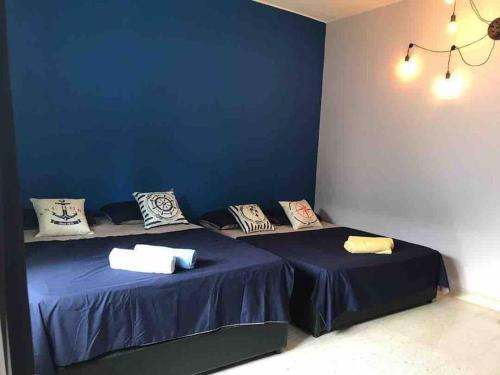 two beds in a room with blue walls at PD BlueBox Bungalow Sailor Theme (Up to 20 Pax) in Port Dickson