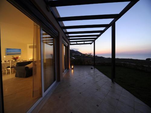 a patio with a view of the ocean at sunset at Villa Avra in Panormos Rethymno