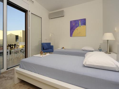 パノルモス・レティムノにあるVilla Avraのベッドルーム1室(ベッド2台、大きな窓付)