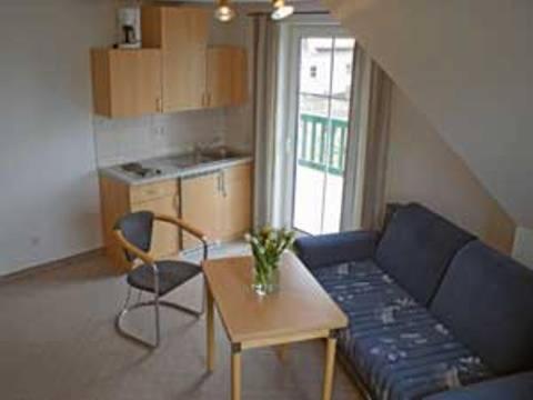 a living room with a blue couch and a table at Landsitz Rügen in Glowe