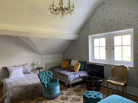 Ris-OrangisにあるDomaine de Risのベッドルーム1室(ベッド2台、椅子、シャンデリア付)
