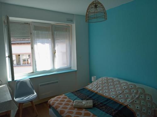une chambre avec un lit, une chaise et une fenêtre dans l'établissement Appartement paisible - cœur de ville, au Creusot