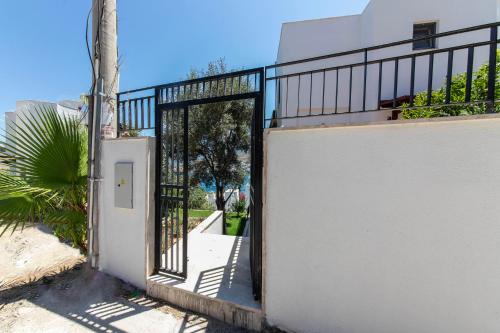 an open door to a white building with a fence at Villa House Apart Türkbükü in Bodrum City