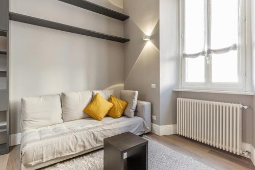 een woonkamer met een bank en een raam bij Easylife - Lusso e comfort nel quartiere Brera in Milaan