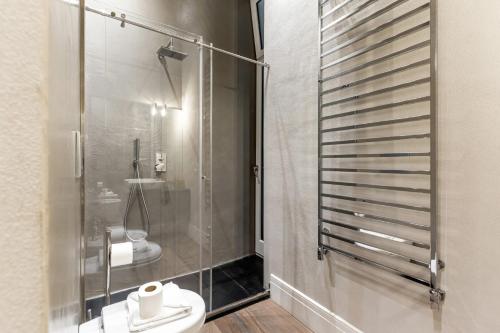 een badkamer met een toilet en een glazen douche bij Easylife - Lusso e comfort nel quartiere Brera in Milaan