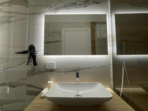 y baño con lavabo blanco y espejo. en Room Corso 219, en Montesilvano