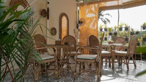 restauracja z krzesłami i stołami oraz patio w obiekcie Whiteflower Resort Morjim w mieście Morjim