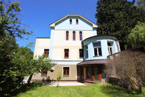 a large white house with a blue roof at Penzion Bačalský mlýn in Morašice