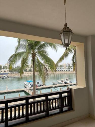 a view of a palm tree from a window at Marina Flat Hawana in Salalah