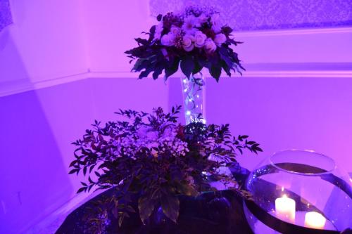 a vase with purple flowers and candles on a table at Hotel Caserta Antica in Caserta