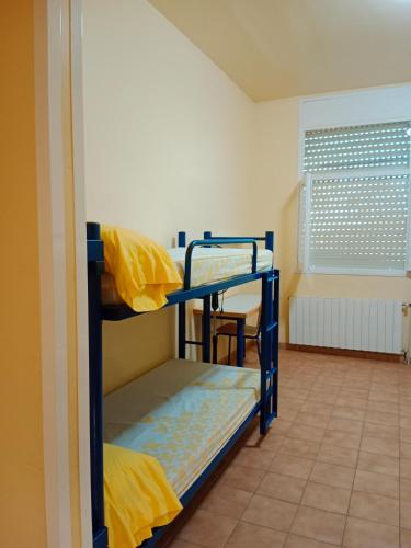 ein Zimmer mit zwei Etagenbetten in einem Zimmer in der Unterkunft Alberg Cabrera de Mar Xanascat in Cabrera de Mar