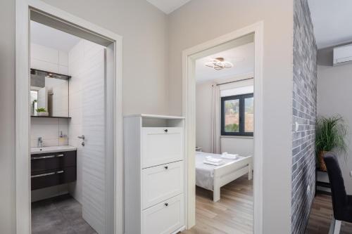 a white bathroom with a sink and a mirror at Villa Emma Pag in Pag