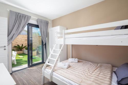 a bedroom with a bunk bed and a ladder at Villa Emma Pag in Pag