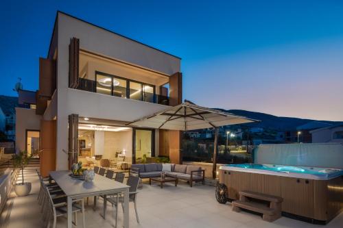 a house with a pool and a patio with a table and chairs at Villa Emma Pag in Pag