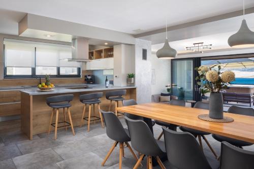 an open kitchen and dining room with a wooden table and chairs at Villa Emma Pag in Pag
