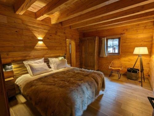 a bedroom with a bed in a wooden cabin at La Boutame : chalet au pied des pistes à Villard Reculas in Villard-Reculas