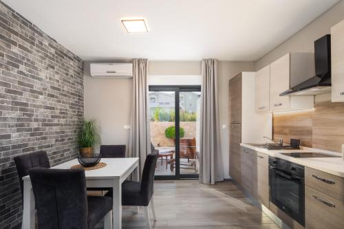 a kitchen with a table with chairs and a dining room at Villa Emma Pag in Pag