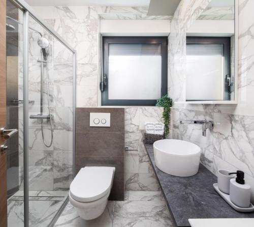 a bathroom with a toilet and a sink and a shower at Villa Emma Pag in Pag