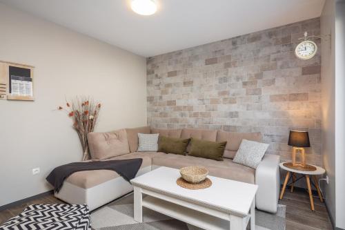 a living room with a couch and a brick wall at Villa Emma Pag in Pag