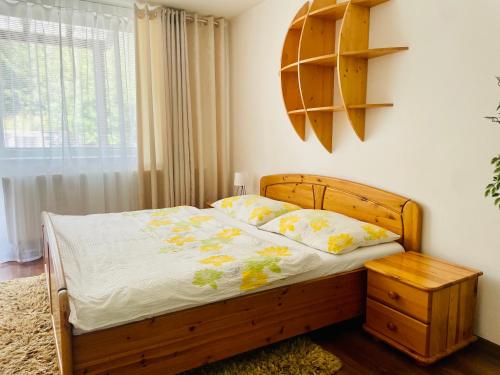 Schlafzimmer mit einem Holzbett mit einem Kopfteil aus Holz in der Unterkunft Apartmanovy dom Slavkov in Veľký Slavkov