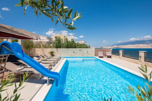a swimming pool with a blue slide in a resort at Villa Emma Pag in Pag