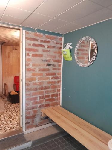 een kamer met een bakstenen muur en een raam bij Ugglebo, stuga in Nauvo