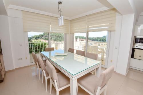 a dining room with a glass table and chairs at Villa Rana The Royal Links Sarigerme in Ortaca