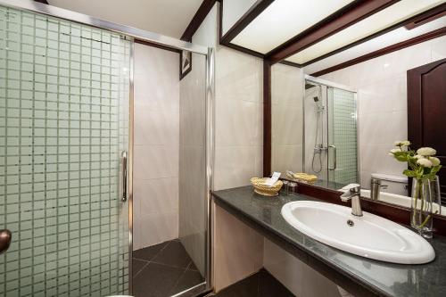 a bathroom with a sink and a shower at Golden Sun Hotel in Vientiane
