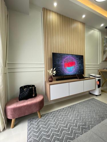 a living room with a large television and a chair at LuxeRN Suite at S Residences in Manila