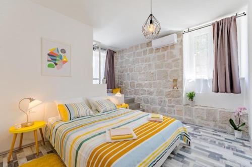 een slaapkamer met een bed en een stenen muur bij Apartment Mia in Split