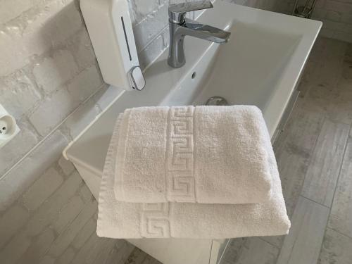 a bathroom with a white sink and a towel on a counter at MAŁY PORT-Iława - Jezioro - Plaża - Marina priv - 5 pokoi VIP - czysto na 10 in Iława