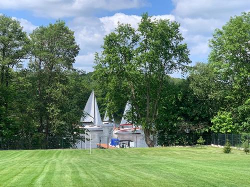 a small white chapel with a sail boat in a field at MAŁY PORT-Iława - Jezioro - Plaża - Marina priv - 5 pokoi VIP - czysto na 10 in Iława