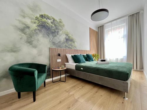 ein Schlafzimmer mit einem Bett und einem grünen Stuhl in der Unterkunft Apartamenty Wolwowicz in Jelenia Góra