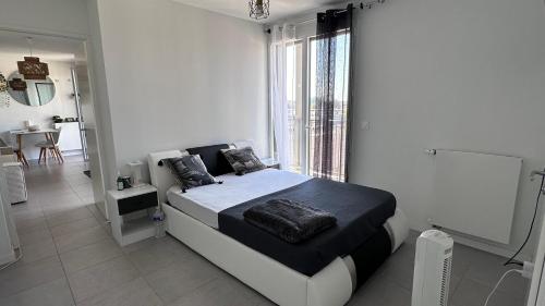 une chambre avec un lit et une grande fenêtre dans l'établissement Ndianda, à Bordeaux