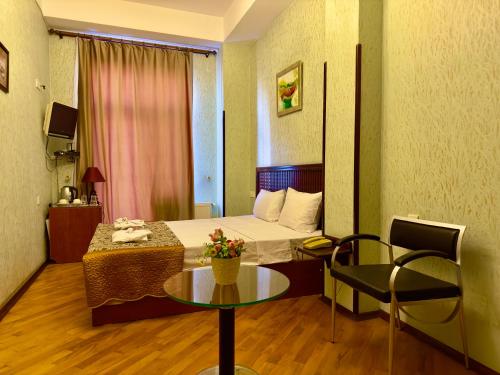 Piccola camera d'albergo con letto e tavolo di Nur Hotel Sea View a Baku
