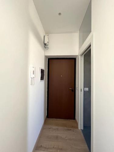 a hallway with a brown door in a building at Nicolosi Apartment in Latina