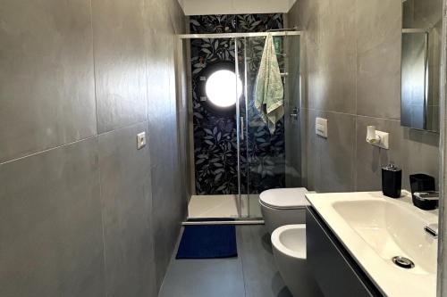 W łazience znajduje się prysznic, toaleta i umywalka. w obiekcie Nicolosi Apartment w mieście Latina