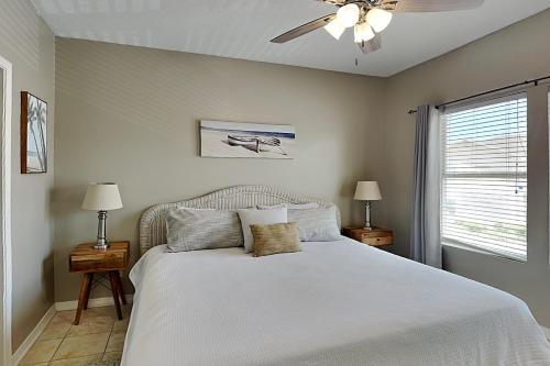 een slaapkamer met een wit bed en een plafondventilator bij Sandpiper Cove 9224 in Destin