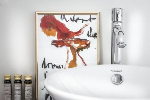 een badkamer met een wastafel en een foto van een giraffe bij Château Charles in Pepinster