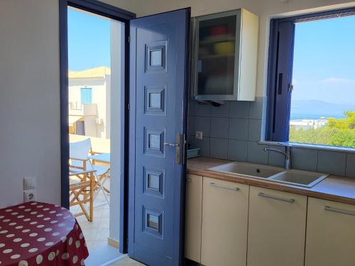 a kitchen with a door leading to a balcony at Aegina Vagia Sea Breeze Vacation Villa in Vaia