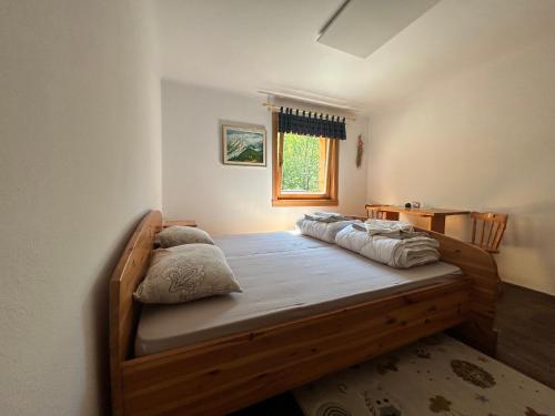 a bedroom with a wooden bed with pillows on it at Mountain hut Dom pod Storžičem in Tržič