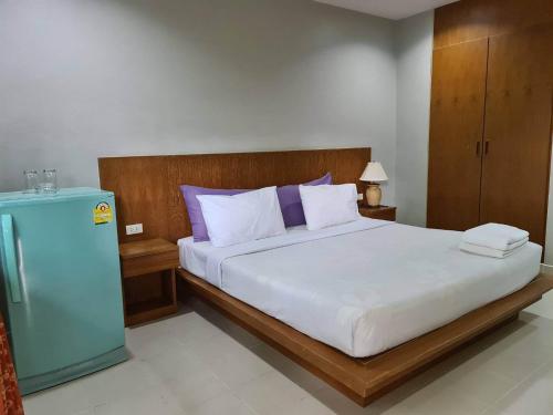 ein Schlafzimmer mit einem großen Bett und einem blauen Kühlschrank in der Unterkunft ก้านกล้วยแมนชั่น Gankluy Mansion in Phuket