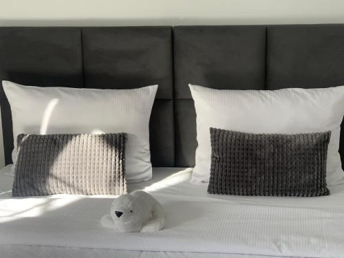 a white teddy bear sitting on a bed with pillows at MAŁY PORT-Iława - Jezioro - Plaża - Marina priv - 5 pokoi VIP - czysto na 10 in Iława