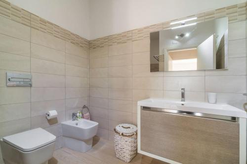 a bathroom with a sink and a toilet and a mirror at Villa Oleandro in Pula
