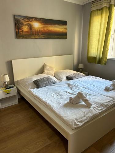 a bed with a pair of shoes sitting on it at Apartmány Formanka na náměstí in Hustopeče