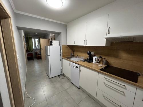 a kitchen with white cabinets and a white refrigerator at Apartmány Formanka na náměstí in Hustopeče