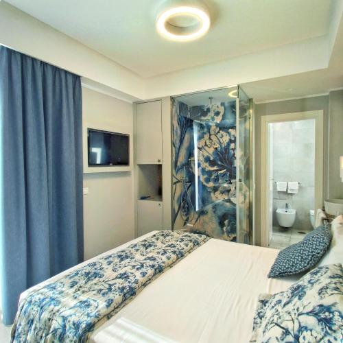 a bedroom with a large bed and a bathroom at Piccolo Hotel in Terracina