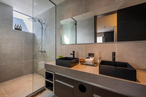 a bathroom with two sinks and a shower at Meikeikyo Hanazono in Kutchan