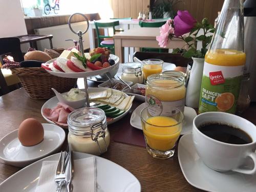 una mesa de madera con alimentos para el desayuno y bebidas. en Pension Central - Ihre Fahrradfreundliche Unterkunft in der Altstadt, en Lutherstadt Wittenberg