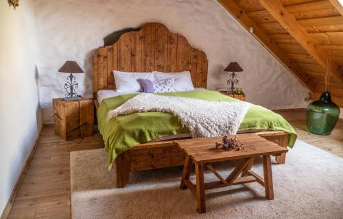 - une chambre avec un grand lit et une tête de lit en bois dans l'établissement Káli Panorama Resort, à Mindszentkálla